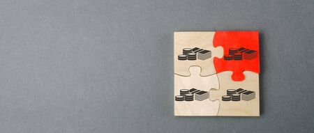 Wooden puzzles with the image of money. Withholding money and commission. Tax and taxation. The taxes burden. Net income. Costs.の写真素材