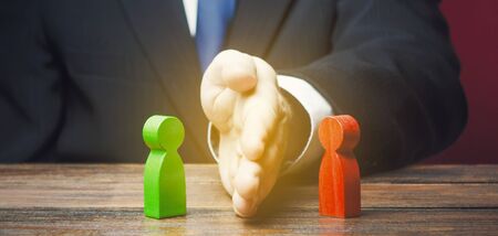 Man divides warring parties conflict with a hand. Mediator services. Stop fight, ceasefire clashes. Finding a compromise. De-escalation of conflict. Avoid the war, start the negotiation processの写真素材
