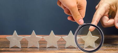 Critic puts the fifth star. The concept of the rating of hotels and restaurants. The evaluation of visitors. Quality level, good service. Best customer rating. Feedback. Satisfactionの写真素材