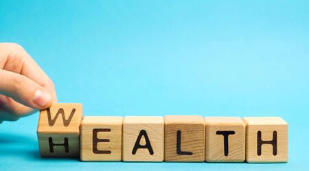 Wooden blocks with the word Health and Wealth. Concept of choosing priority in life and lifestyle....