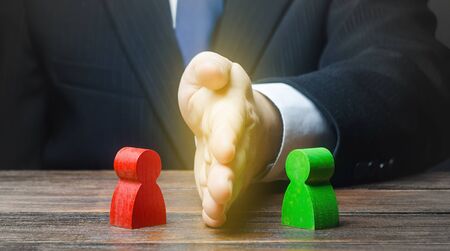 Man puts his hand between conflicting persons. Avoidance violence, preventing conflict escalation. Stop fight, ceasefire. Find a compromise. Lawsuit trial. Witnesses protection. Mediator services.の写真素材