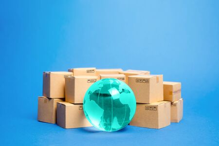 Earth globe is surrounded by boxes. Global business and international transportation of goods products. Shipping freight, world trade and economics. Distribution, import export. Commodity turnoverの写真素材