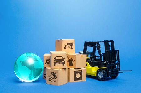 Forklift truck near cardboard boxes and blue globe. Transportation logistics infrastructure, import export of goods. Freight shipping. Globalization of production, sales of products on world markets.の写真素材