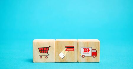 Wooden blocks with online shopping symbols. Shopping cart, card for payment, delivery truck. Seller over the Internet. Ecommerce and delivery service conceptの写真素材