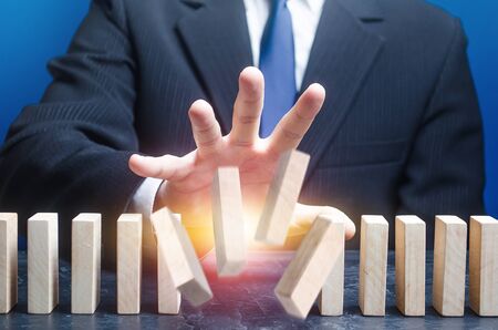 Man destroys order of standing domino row. Spoil plans, ruin business processes. Instability, hit a...