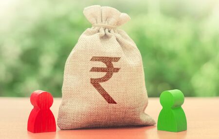 Indian rupee money bag and a deal between two persons. Business lending, leasing. Tender competitiona contract. Trade agreement. Negotiation process dealings. Dispute solution. Finance surety promiseの写真素材