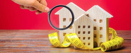 Miniature wooden houses and measuring tape. Home appraisal and property valuation concept. Housing construction, repair and maintenance. Real estate appraiserの写真素材