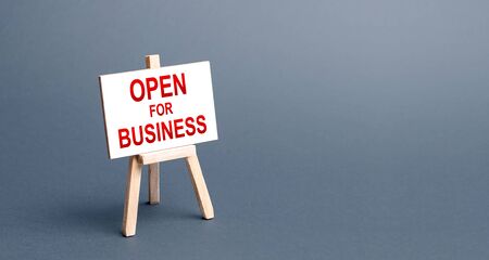 Open for business easel sign. Opening a business of establishments, resuming economic life after a long closure. Economy recovery from the crisis. Financial support, preferential cheap loans.の写真素材