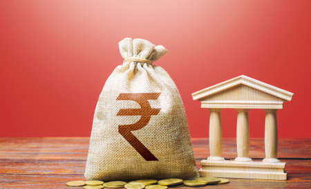 Indian rupee money bag and bank / government building. Tax collection and budgeting. GDP and GNP. Monetary policy. Support businesses in times of crisis. Lending loans, deposits. State debt.の写真素材