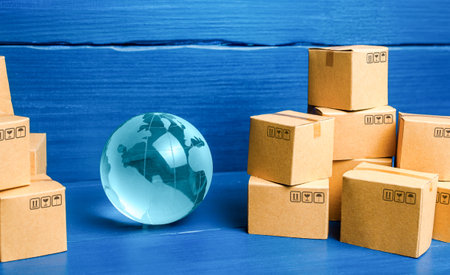 Planet Earth globe and cardboard boxes mass consumption products. Delivering goods around the world. International trade and transportation of goods. Shipping freight. Transnational business industry.の写真素材