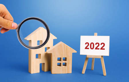 Inscription 2022 and miniature houses. Real estate concept. Family budget planning. Investments, plans, savings. Mortgage and mortgage rates. Forecasts. Loan. Refinance homeの写真素材