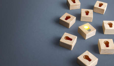 One glowing light bulb idea among many dark off. Concept choosing best suitable idea from presented. Developing startup. Business accelerator. Innovation promising technologies. Search for talent.の写真素材