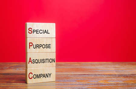 Wooden blocks with the word SPAC - Special purpose acquisition company. Simplified listing of company, merger bypassing stock exchange IPO. Assessment of benefits and risks of investmentsの写真素材