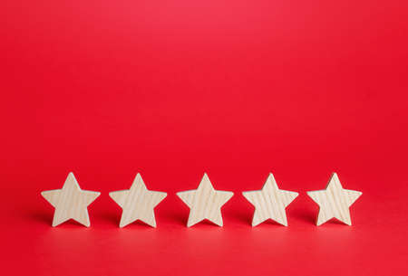 Five stars on a red background. Rating evaluation concept. Service quality feedback. High satisfaction. Good reputation. Popularity rating of restaurants, hotels or mobile applications. Highest scoreの写真素材