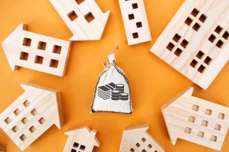 Money bag and many wooden house. Real estate investment concept. Business and finance. Mortgage,...