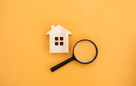 Magnifying glass and wooden houses. House searching concept. Home appraisal. Property valuation. Choice of location for the construction. Search for housing, apartments. Real estate appraiser servicesの写真素材
