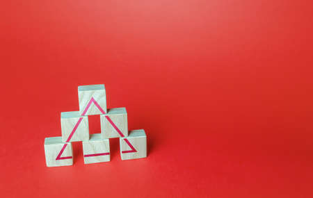 Wooden blocks make a triangle. Society or business ranking system concept. Abstraction of solidity. Unity and discipline. Building a team, teamwork cooperation. Systemic organization.の写真素材