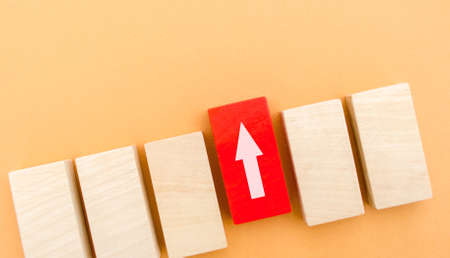 One red block with up arrow stands out from the rest. Leadership and victory concept. Dissimilarity and dissent. Uniqueness initiative. Superfluous, unsuitable. Going beyond. Untypical Conceptの写真素材