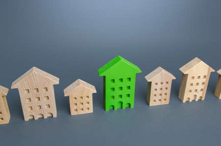 Green residential building among houses. Environmentally friendly, energy efficient and zero carbon emissions. Search for the best option to buy an apartment. Net Zero Carbon neutrality. High qualityの写真素材