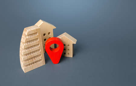 Residential buildings and a red location pin. Location, accessibility and proximity to infrastructure. Visit the town. Search for housing options. City navigation, orienteering. Realtor service agencyの写真素材