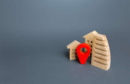 Red location pin near houses. Location concept, settlement. City navigation, orienteering. Search for housing options. Tracking, internet of things. Infrastructure and surroundings. Local searching.の写真素材