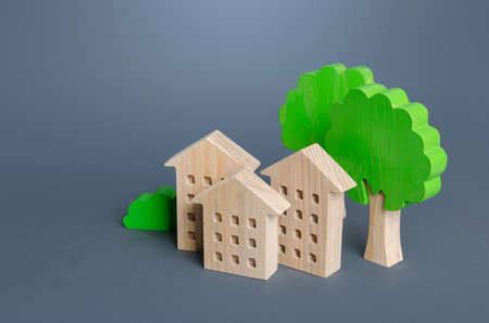 Residential buildings among the trees. Environmentally friendly, energy efficiency, zero carbon emissions. Buying and selling real estate. Renting housing, realtor services. Carbon neutrality.の写真素材