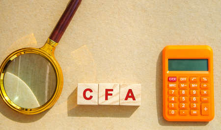 Wooden blocks with the words CFA - Chartered Financial Analyst. Postgraduate professional...