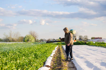 Kherson oblast, Ukraine - May 4, 2021: Farmer sprays a potato plantation against pests and fungi. Protection of cultivated plants from insects and fungal infections. Control of use of chemicals.のeditorial素材