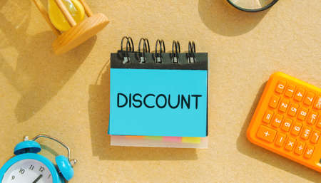 Notes with the word discount, calculator and hourglass. Discounts on goods and services. Sale, sell-out, clearance sale. Business and finance conceptの写真素材