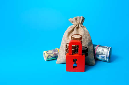 Money bag and red padlock. Sanctions and Restrictions. Freezing of assets, seizure of savings and property. Fund reservation. Transaction restrictions. Unavailability of loans, low credit rating.の写真素材