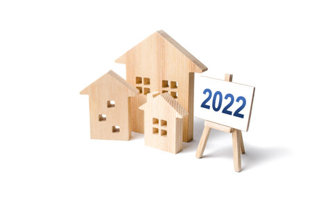Residential buildings and easel 2022. Concept of real estate market in new year. Housing market predictions, trends and tendencies. Investment plans. Mortgage loan. Economic analysis. Home loansの写真素材