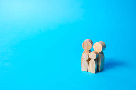 Family figures of parents and kids on a blue background. Family values and health. Adoption and custody of children. Social support, demography, sociology. Upbringing and education. Together conceptの写真素材