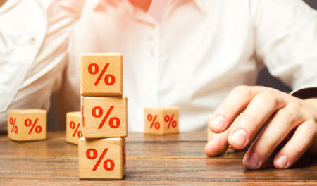 Man and interest rates. Interest rate on loan or deposit. Profit investments, dividends and yield on securities assets. Debt burden, high indebtedness. Financial literacy. Credit score calculationの写真素材