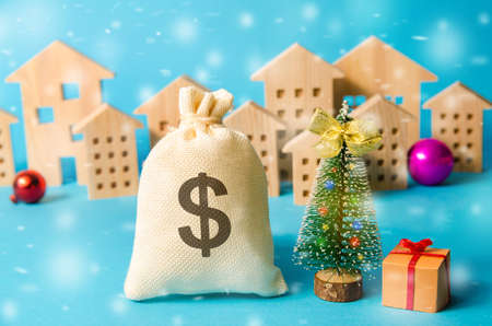 Dollar money bag, Christmas tree and miniature houses. Accumulating money and planning a budget. Business and finance. Loans, deposit, credit. Promotions, offers. Selective focusの写真素材