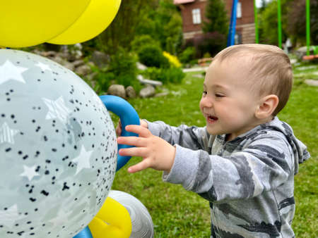 Toddler boy playing with balloons outdoors. A cute boy of one and a half years. selective focus