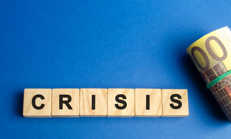 Wooden blocks with the word Crisis and euro bills. Avoid or end economic political crisis. Recovery,...