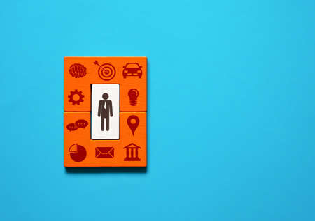 A businessman surrounds himself with business attributes, qualities and leadership skills to manage...
