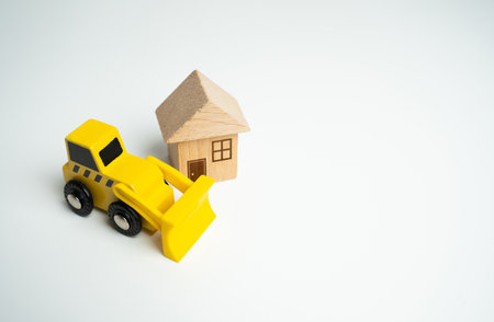 bulldozer and house. Demolition services, land leveling and other land works for construction. Encroachment on private property. Illegal buildings. Violation of building codes. housing renovation.の写真素材