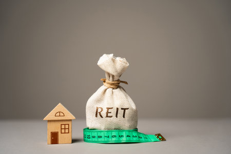 Reit money bag and miniature house. Real estate investment trust concept. Company that owns, operates, or finances income-generating real estate.の写真素材