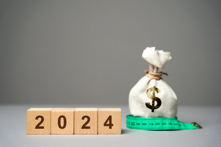 Wooden blocks 2024 and money bag with dollars. budget planning. business and economic concept. Goals...