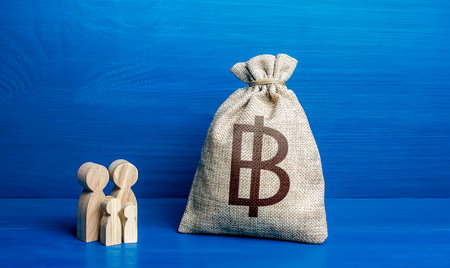 Family figurines and thai baht money bag. family budget. Investment in human capital. Refugees crisis. Favorable conditions for population growth. Demography. Income, expenses.の写真素材