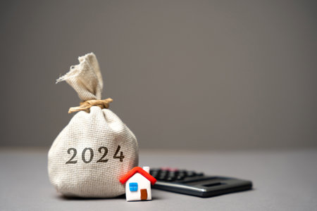 2024 budget real estate concept. family budget planning. Investments, plans, savings. Mortgage and mortgage rates. Forecasts. loan. Refinance home. Money bag and miniature house.の写真素材