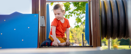 Cute toddler boy two or three years old is playing on the playground outside. Healthy summer activity for children. Children's games. Selective focusの写真素材
