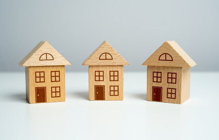 Three wooden toy houses. Offers on real estate market. Mortgage. Valuation of residential buildings. Realtor services. Buying and selling. Find the most suitable housing options.の写真素材