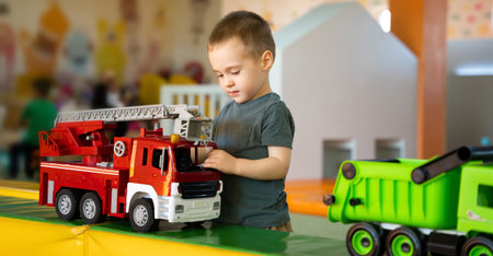 Cute toddler boy playing with cars in children's playroom. Active lifestyle, childhood. Selective focusの写真素材
