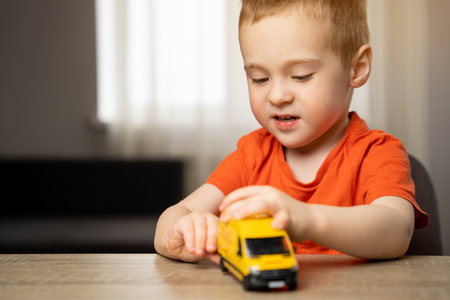 Cute toddler boy playing with a toy yellow car. Children's leisure and lifestyle. Childhood. Focus on the child.の写真素材