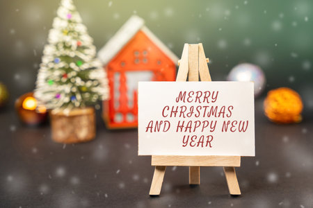Easel with the words Happy New Year and Merry Christmas. New Year or Xmas winter holiday. Decoration, celebration. The concept of the beginning of the new year. Snow, snowfallの写真素材