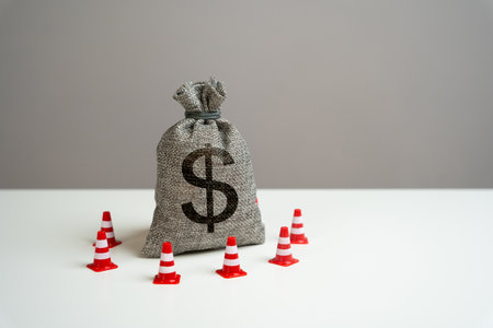 Dollar money bag blocked by road cones. Freezing of accounts and sanctions on capital. Dedollarisation. Suspicious funds with unknown sources. National money reserve.の写真素材