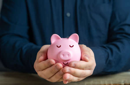 A calmly sleeping piggy bank in the hands. Trust fund. A reliable way to store savings and passive income. Savings and deposit banking. Wealth and prosperity. Successful investments and deposits.の写真素材