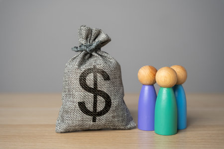 People figurines and dollar money bag. Compensation payments. Social assistance. Financial support. Providing money, paying salaries and grants.の写真素材